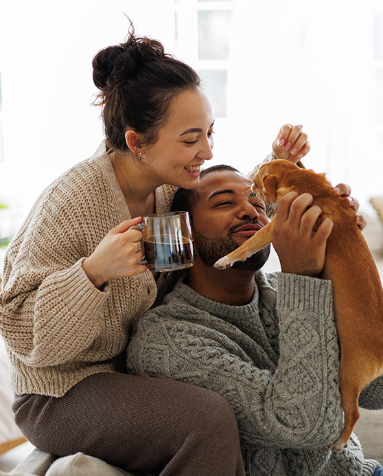 Happy couple playing with their puppy