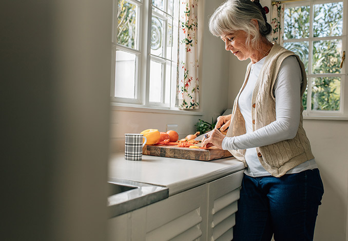 Older woman chopping vegetables