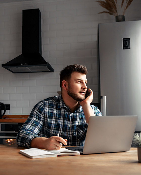 Man using his computer while on the phone