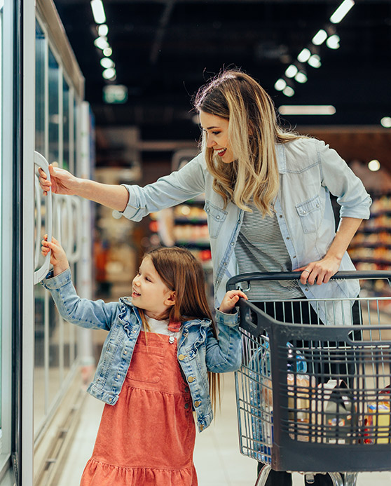 Mother and young daughter grocery shopping