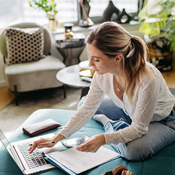 Woman sitting on couch working on security papers
