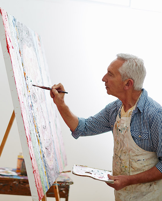 Senior man painting on an easel